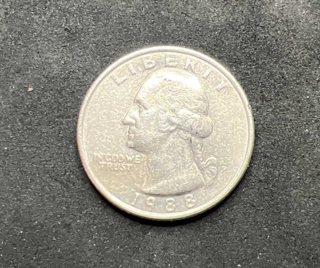 1988 quarter missing clad layer error showing copper-orange obverse face next to normal silver-gray reverse